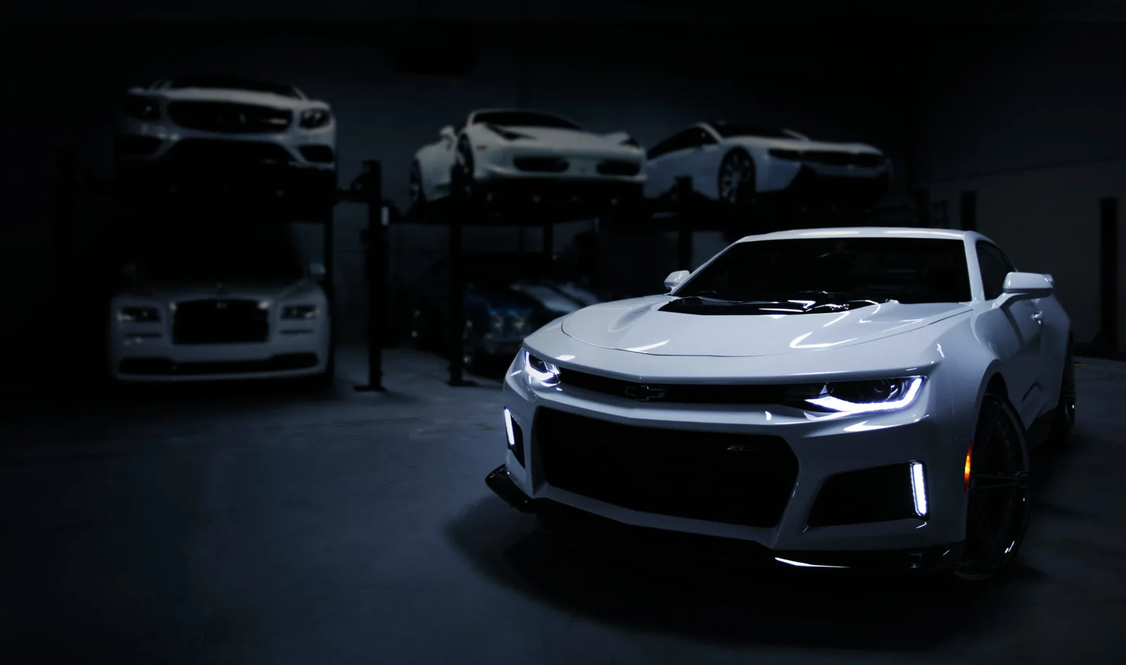 A customer car parked inside a workshop alongside other vehicles