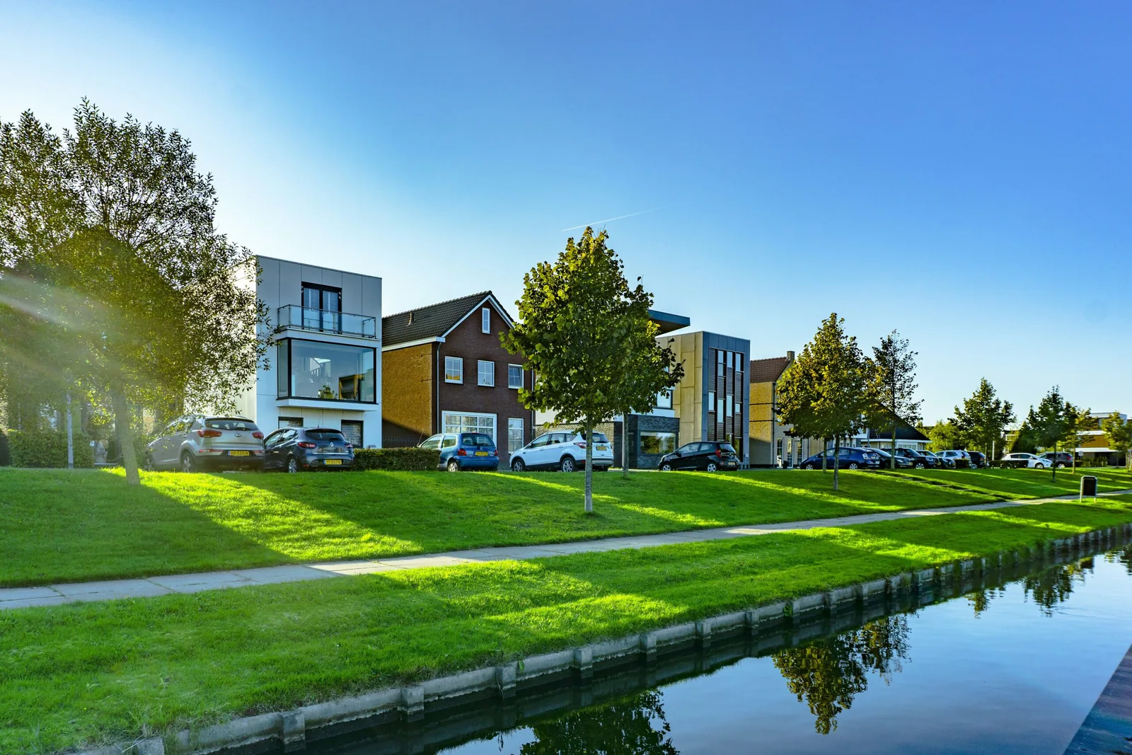 A row of two-storey houses along a canal on a clear day