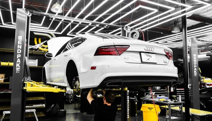 white car on vehicle lift for repairs