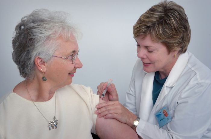 Home healthcare provider assisting an elderly patient in their home.