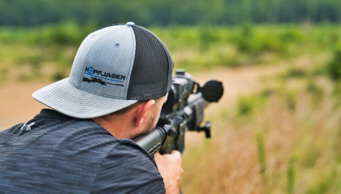 guy shooting a rifle in a field